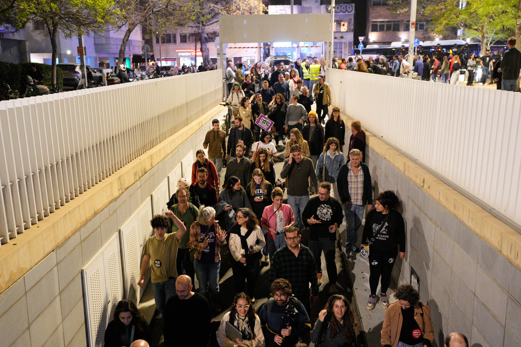 People enter an underground parking garage as sirens warn of an incoming missile fired from Yemen in Tel Aviv, Israel, Saturday, April 4, 2026. (AP Photo/Maya Levin)