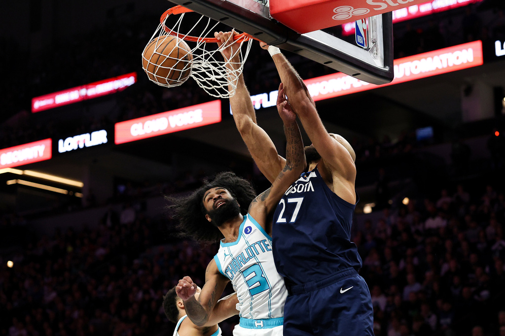 Minnesota Timberwolves center Rudy Gobert, right, winks over Charlotte Hornets guard Coby White (3) during the first half of an NBA basketball game, Sunday, April 5, 2026, in Minneapolis. (AP Photo/Matt Krohn)