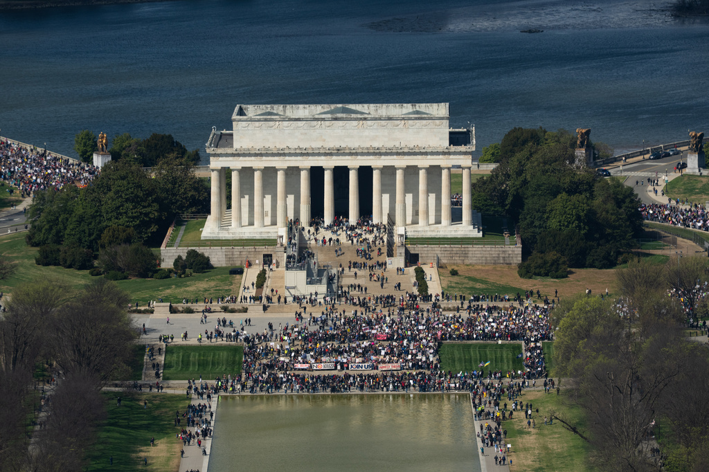 Demonstrators march across Memorial Bridge and around the Lincoln Memorial during the No Kings protest in Washington, Saturday, March 28, 2026. (AP Photo/Allison Robbert)
