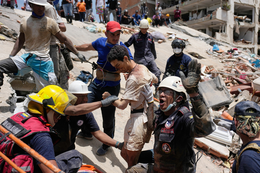 Rescue workers pull Daniel Cordero from the rubble of his home in Catia la Mar, Venezuela, Friday, June 26, 2026, two days after twin earthquakes struck the country. (AP Photo/Fernando Vergara)