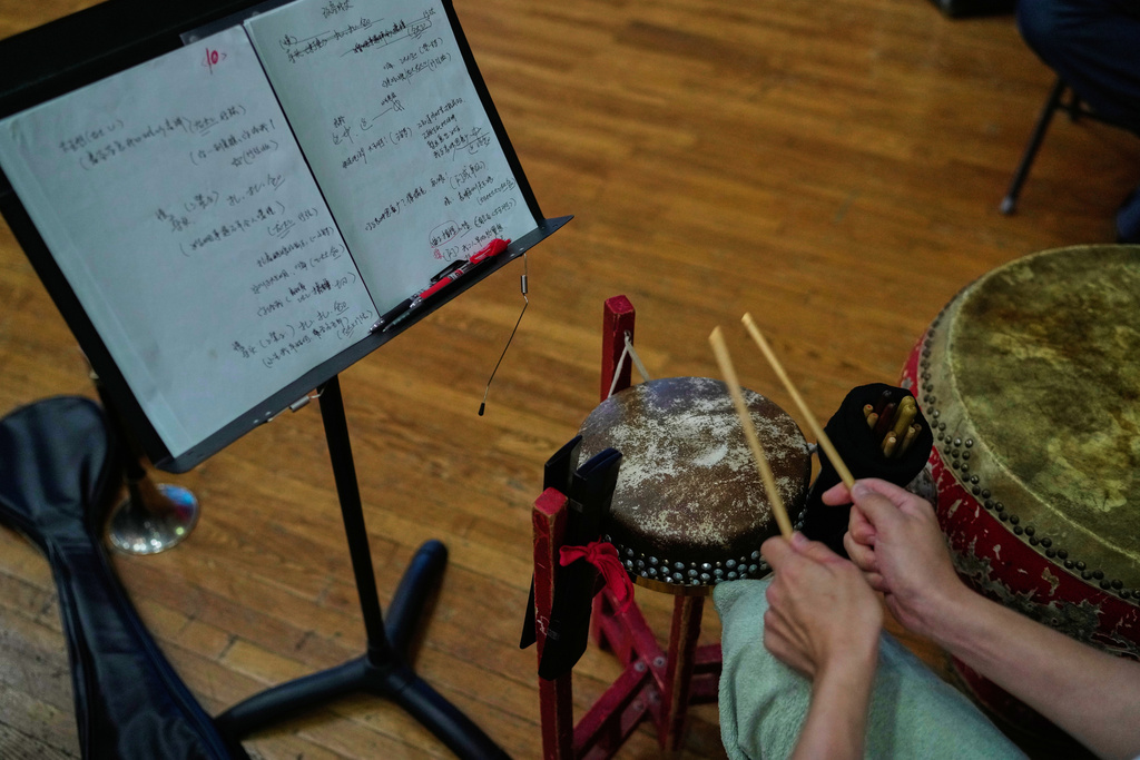 A drummer plays a traditional drum during a rehearsal for a Peking Opera show in Beijing, China, Friday, Sept. 5, 2025. (AP Photo/Mahesh Kumar A.)