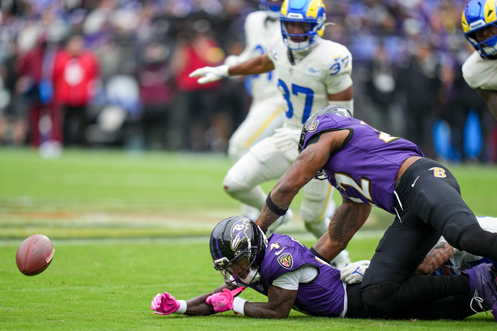 Baltimore Ravens wide receiver Zay Flowers (4) fumbles the ball before Los Angeles Rams safety Quentin Lake (37) recovered it during the second half of an NFL football game Sunday, Oct. 12, 2025, in Baltimore. (AP Photo/Stephanie Scarbrough)