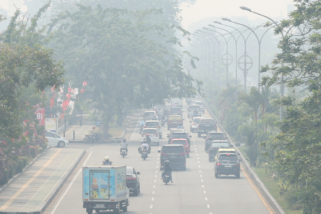 Motorists ride on a road as haze from wildfires blankets the city of Pontianak, West Kalimantan, Indonesia, Friday, Aug. 21, 2026. (AP Photo/Stefanus Taman)