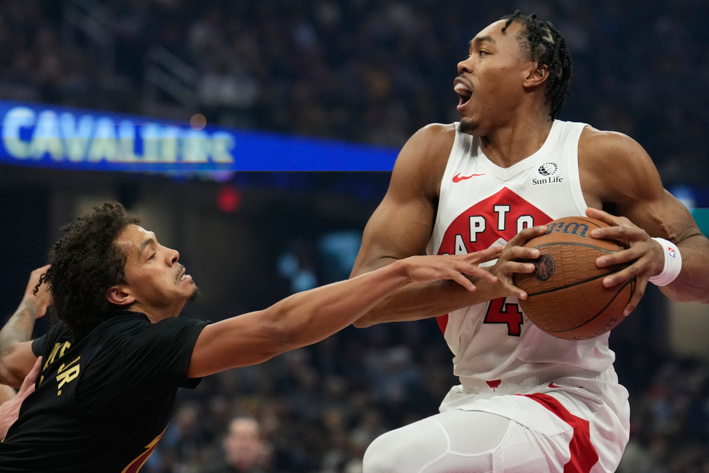 Toronto Raptors' Scottie Barnes (4) is defended by Cleveland Cavaliers' Craig Porter Jr., left, in the first half of an an NBA Cup basketball game in Cleveland, Friday, Oct. 31, 2025. (AP Photo/Sue Ogrocki)