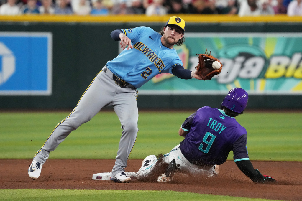 Arizona Diamondbacks' Tommy Troy (9) steals second base under the tag by Milwaukee Brewers second baseman Brice Turang in the seventh inning of a baseball game, Friday, July 3, 2026, in Phoenix. (AP Photo/Rick Scuteri)