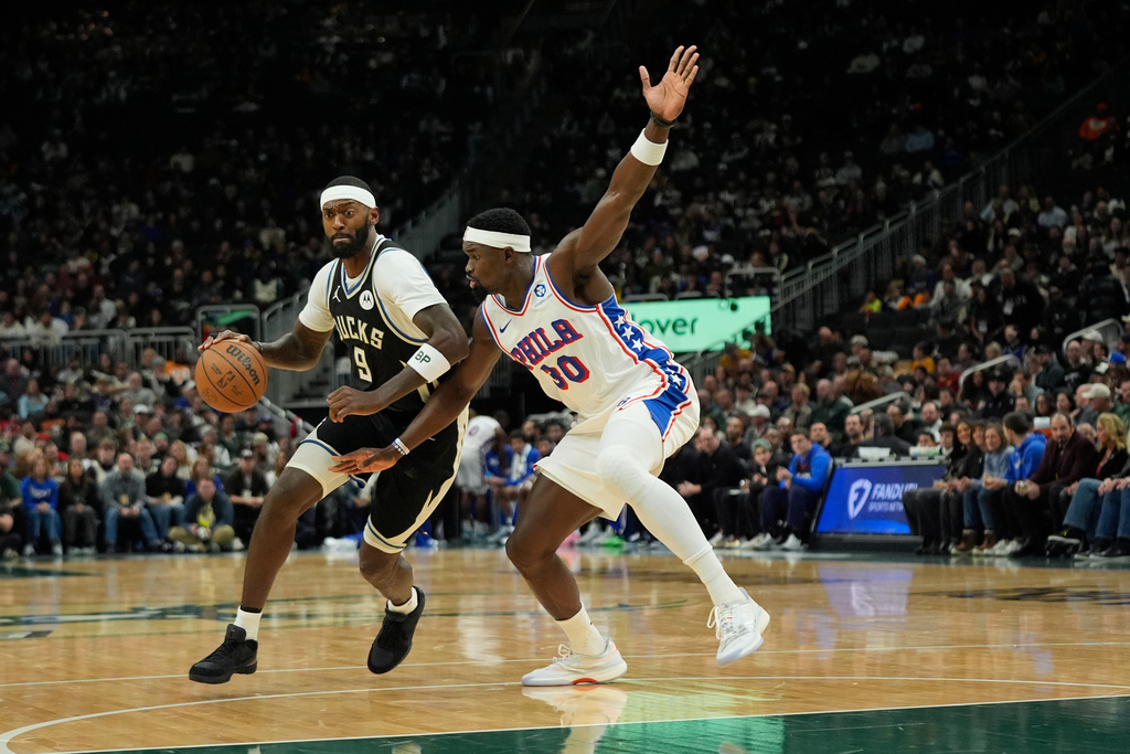 Milwaukee Bucks' Bobby Portis (9) drives to the basket against Philadelphia 76ers' Adem Bona (30) during the first half of an NBA basketball game Friday, Dec. 5, 2025, in Milwaukee. (AP Photo/Aaron Gash)