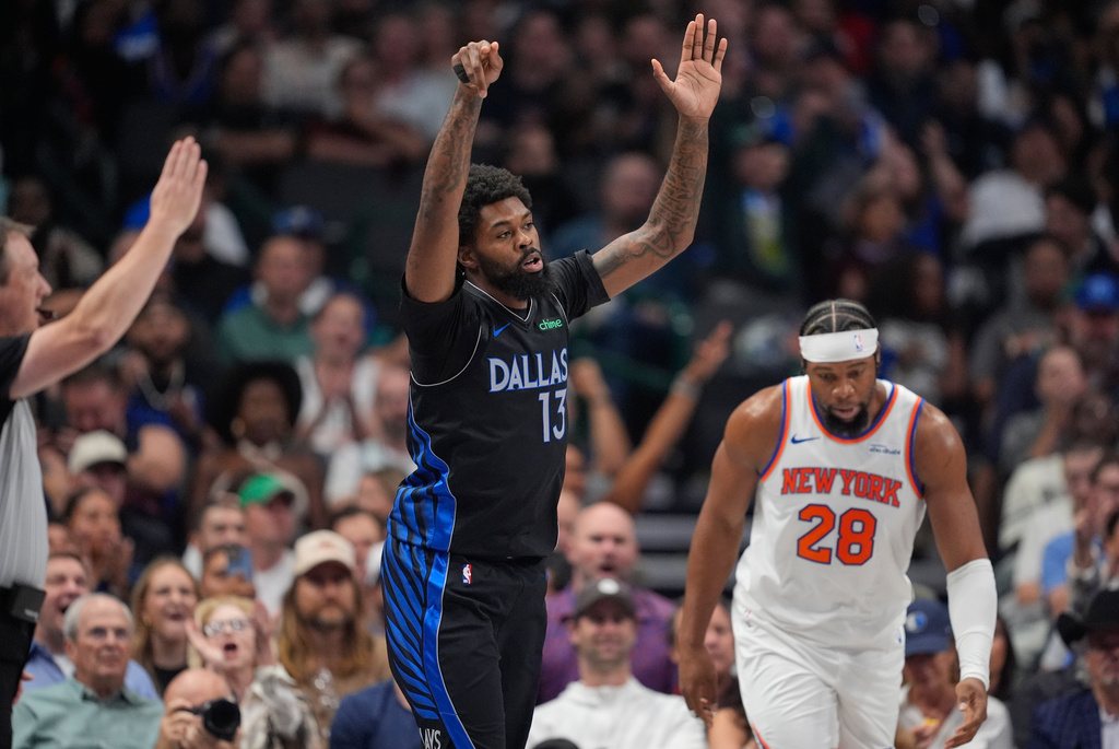 Dallas Mavericks forward Naji Marshall (13) reacts to scoring a three pointer against New York Knicks forward Guerschon Yabusele (28) in the first half of an NBA basketball game Wednesday, Nov. 19, 2025, in Dallas. (AP Photo/Tony Gutierrez)