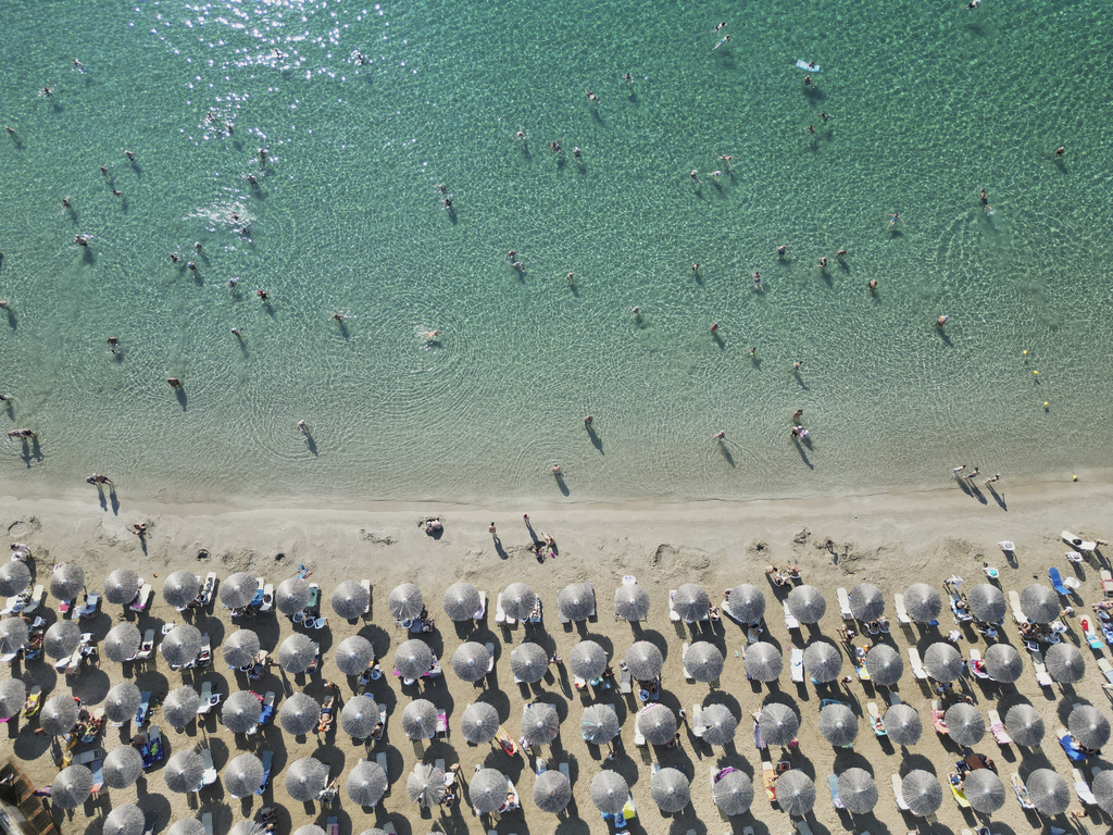 People enjoy the sea in Avlaki beach about 42 kilometers (26 miles) east of Athens, Greece, Wednesday, Aug. 19, 2025. (AP Photo/Thanassis Stavrakis)