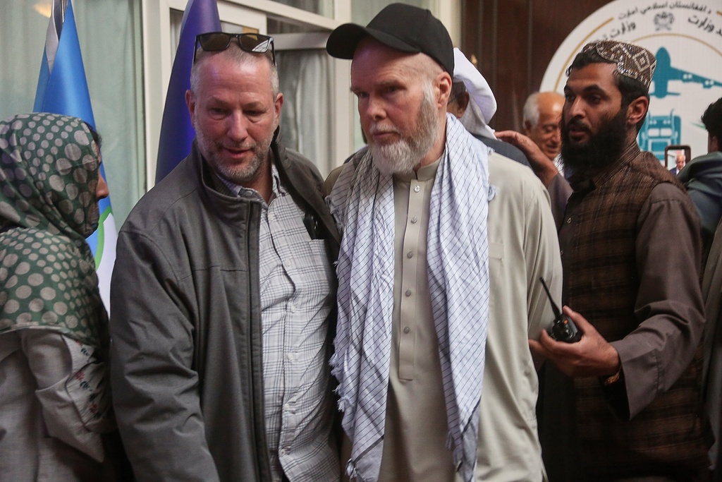 American Dennis Coyle, second from right, is accompanied by an unidentified person after being released by Afghanistan's Taliban authorities, who had held him for over a year, before boarding a plane at the airport in Kabul, Afghanistan, Tuesday, March 24, 2026. (AP Photo/Mudassir Safi)