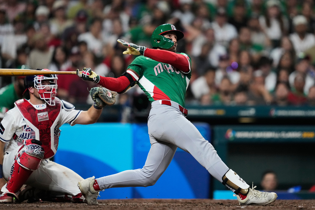 Mexico's Jarren Duran, right, hits a solo home run during the eighth inning of a World Baseball Classic game against the United States, Monday, March 9, 2026, in Houston. (AP Photo/Ashley Landis)