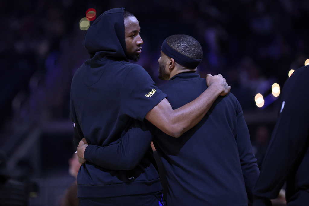 Golden State Warriors' Jonathan Kuminga and Gary Payton II embrace before they play the Miami Heat during an NBA basketball game at Chase Center in San Francisco on Monday, Jan. 19, 2025. (Scott Strazzante/San Francisco Chronicle via AP)