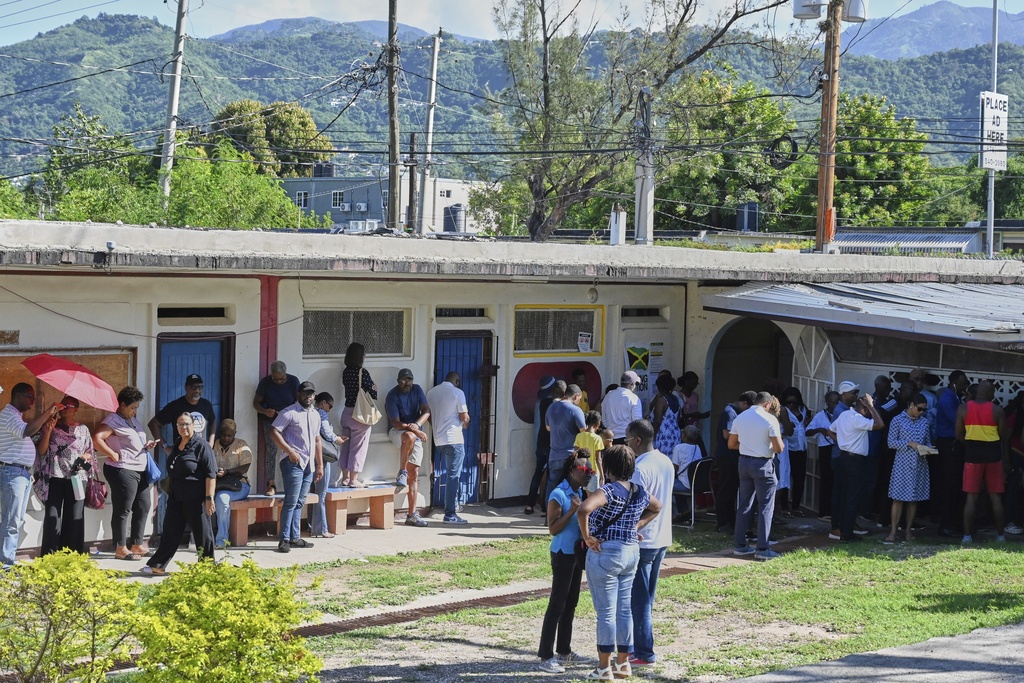 People stand in line to vote at a polling station during general elections in Kingston, Jamaica, Wednesday, Sept. 3, 2025. (AP Photo/Collin Reid)