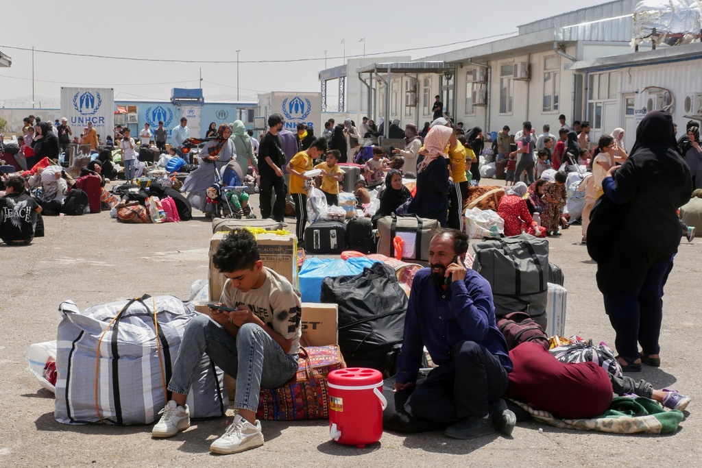 FILE.- Afghan refugees who returned after fleeing Iran to escape deportation and conflict gather at a UNHCR facility near the Islam Qala crossing in western Herat province, Afghanistan, on Friday, June 20, 2025. (AP Photo/Omid Haqjoo,File)