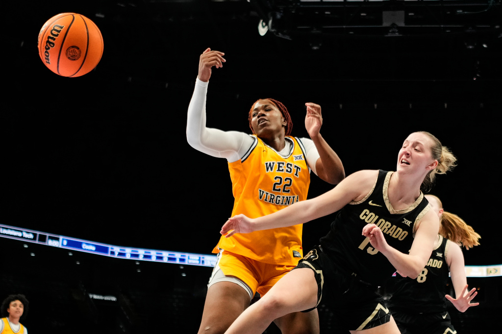 West Virginia's Kierra Wheeler (22) and Colorado's Maeve McErlane, right, chase a rebound during second half of an NCAA college basketball game in the semifinals of the Big 12 Conference tournament Saturday, March 7, 2026, in Kansas City, Mo. (AP Photo/Charlie Riedel)