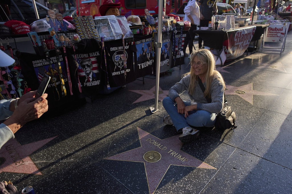 FILE - Silvia Camino, visiting from Argentina, takes photos with the Donald Trump star on the Hollywood Walk of Fame in Los Angeles, Friday, April 4, 2025. (AP Photo/Jae C. Hong, File)