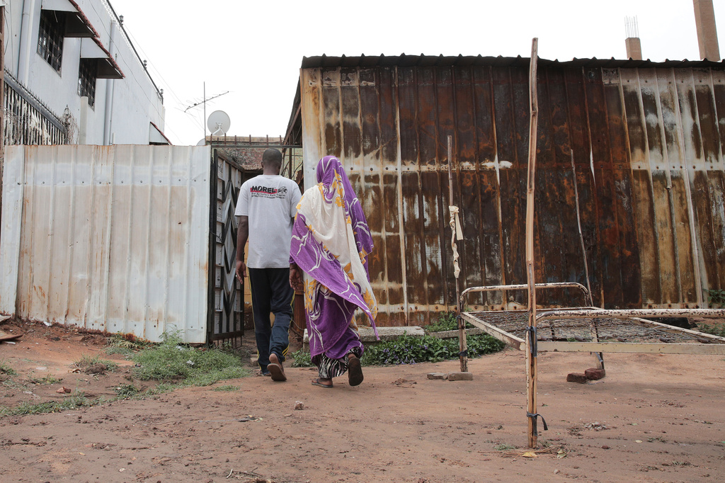 Mohammed Al Mustafa, 41, and his mother Afaf El-Tayeb, 63, arrive at their damaged and looted home, during fighting between the Sudanese Armed Forces (SAF) and the paramilitary Rapid Support Forces (RSF), after their return following the civil war in Khartoum, Sudan, Friday, Aug. 15, 2025. (AP Photo/Marwan Ali)