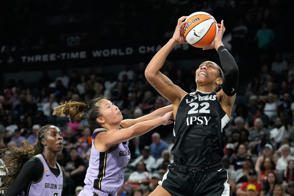 Las Vegas Aces center A'ja Wilson (22) grabs a rebound over Golden State Valkyries guard Kaitlyn Chen (2) during the second half of a WNBA basketball game Sunday, June 21, 2026, in Las Vegas. (AP Photo/John Locher)