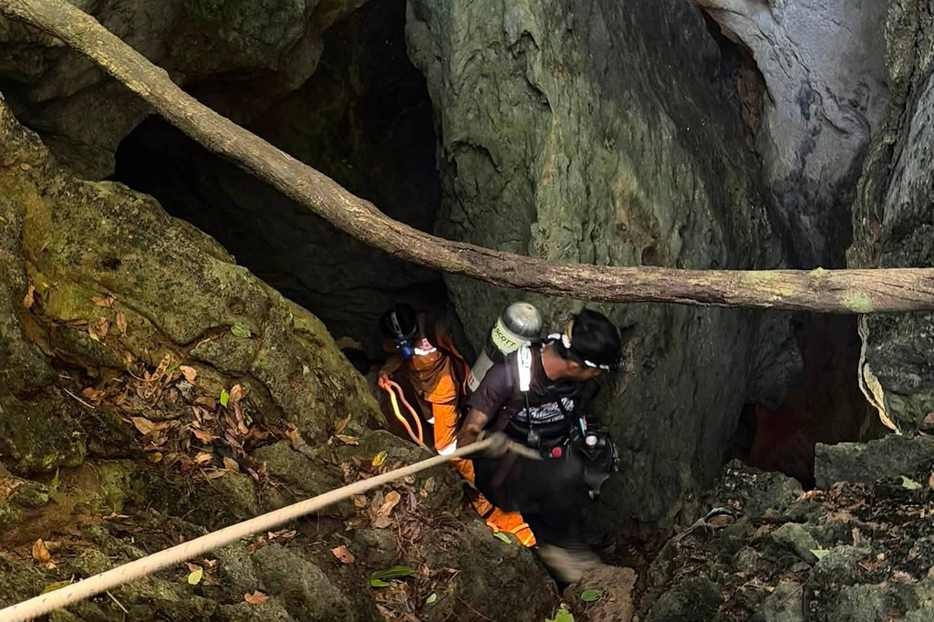 In this image released by Metta Tham Rescue Kalasin, rescuers try to reach people who have been trapped in a cave in Xaisomboun province, Laos, Tuesday, May 26, 2026. (Metta Tham Rescue Kalasin via AP)