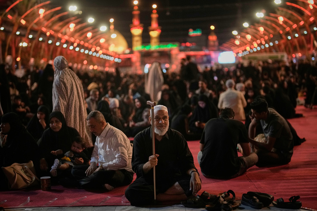 Mourners sit outside the Imam Hussein Shrine on the eve of of funeral ceremonies for the late Iranian Supreme Leader Ayatollah Ali Khamenei in Karbala, Iraq, Tuesday, July 7, 2026. (AP Photo/Khalil Hamra)
