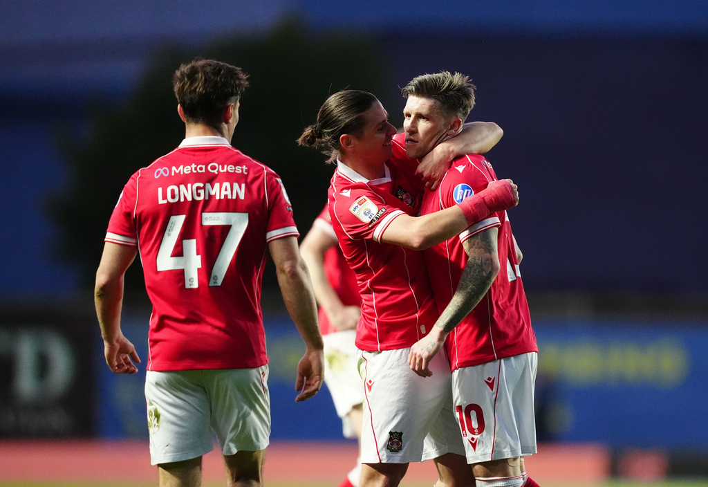 Wrexham's Josh Windass, right, celebrates with teammates after scoring their first goal during the EFL Championship soccer match between Oxford United and Wrexham, Tuesday, April 28, 2026, in Oxford, England. (David Davies/PA via AP)