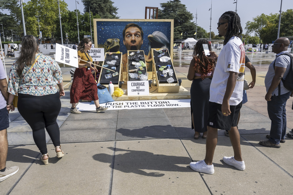 People observe a demonstration by the World Wildlife Fund against plastic waste during the ongoing plastics treaty negotiations in front of the United Nations office in Geneva, Switzerland, Wednesday, Aug. 13, 2025. (Martial Trezzini/Keystone via AP)
