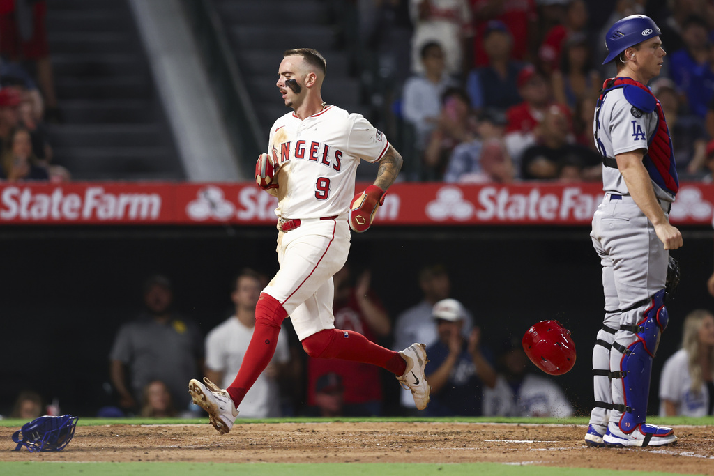 Los Angeles Angels' Zach Neto (9) runs to score off an RBI single by designated hitter Mike Trout as Los Angeles Dodgers catcher Will Smith, right, looks on during the fifth inning of a baseball game, Monday, Aug. 11, 2025, in Anaheim, Calif. (AP Photo/Jessie Alcheh)