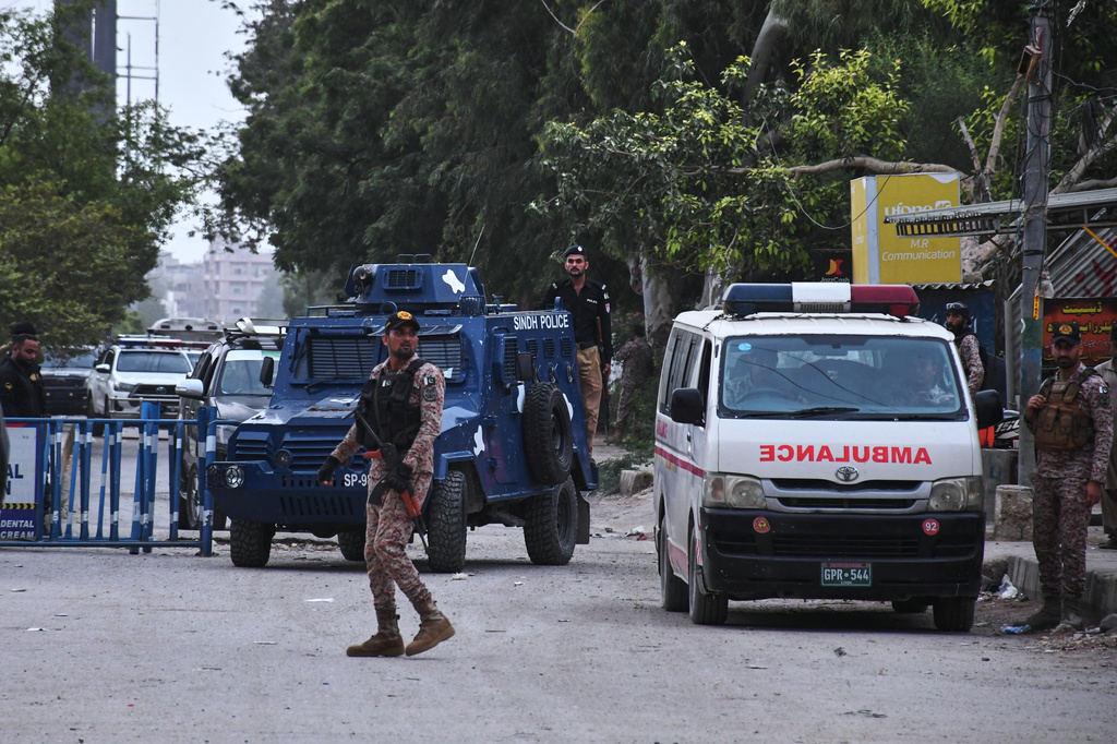 Paramilitary soldiers and police officers stand guard on a road cordoned off near the site of a militant attack at the provincial headquarters of the paramilitary Pakistan Rangers in Karachi, Pakistan, Sunday, June 28, 2026. (AP Photo/Ali Raza)