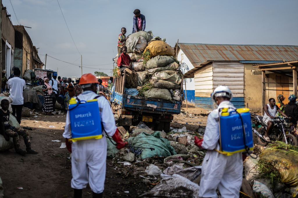Sanitation workers from Bunia city government spray disinfectant in the central market area near a rubbish truck in Ituri province, as they continue efforts to combat the Ebola outbreak in Bunia, Congo, Saturday, May 23, 2026. (AP Photo/Moses Sawasawa)