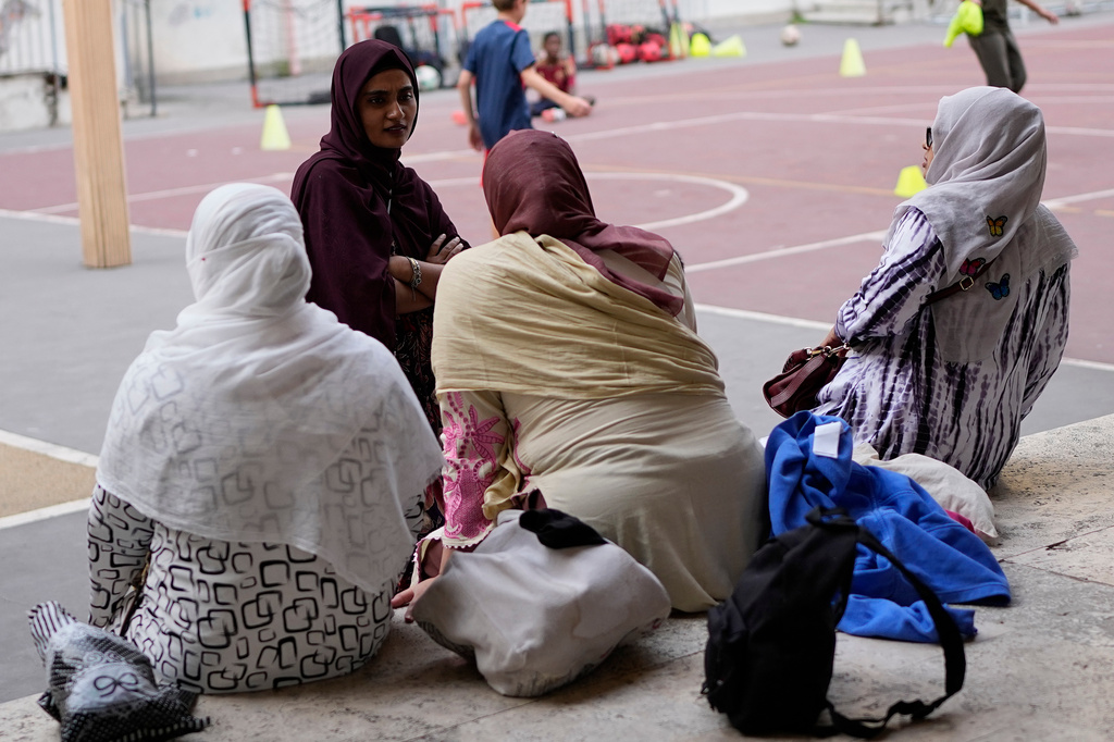 Jannatur Nayeem, 33, an Italian citizen of Bangladeshi origin, top left, chats with other mothers as they wait for a sports lesson to end at a school in downtown Rome, Thursday, Sept. 24, 2026. (AP Photo/Alessandra Tarantino)