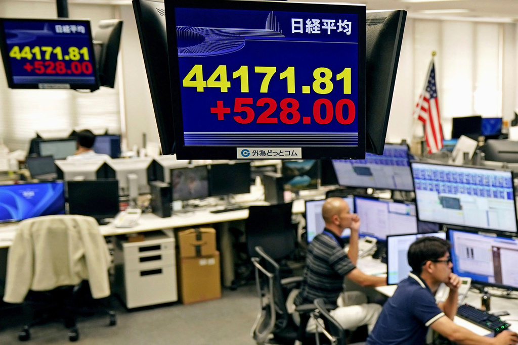 Employees of a foreign exchange dealing company sit under an electronic board showing the stock index of Japan's Nikkei 225, in Tokyo Tuesday, Sept. 9, 2025, in Tokyo. (Kyodo News via AP)