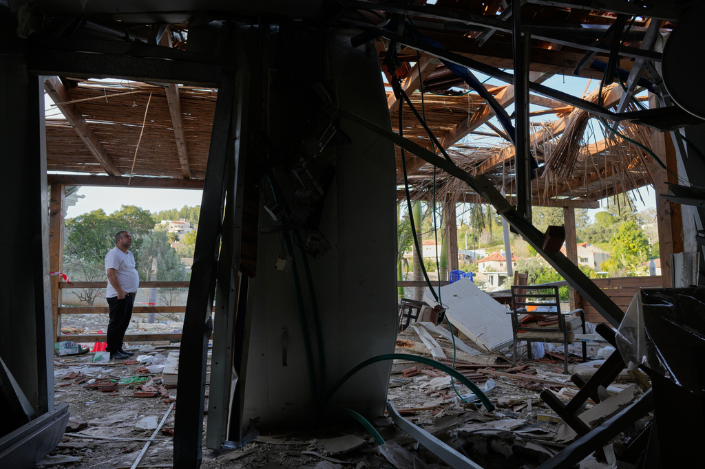 Residents inspect their home after it was struck by an Iranian missile in Eshtaol, central Israel, Saturday, March 28, 2026. (AP Photo/Maya Levin)
