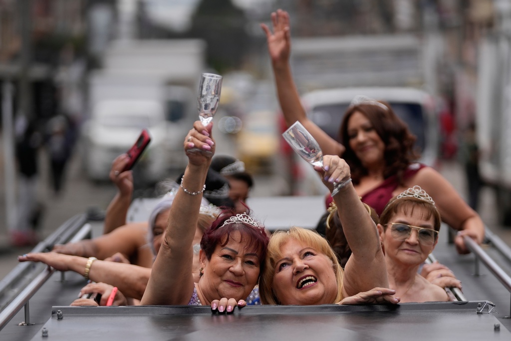 Blanca Guerrero, 67, left, and Gloria Sanabria, 67, right, ride in a limousine to a quinceanera celebration for women who never had a traditional 15th birthday party, organized by the Suenos Hechos foundation in Bogota, Colombia, Friday, Oct. 24, 2025.(AP Photo/Fernando Vergara)
