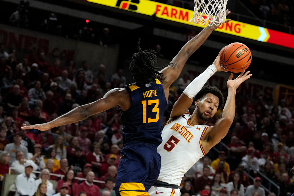 Iowa State forward Joshua Jefferson (5) looks to pass the ball over West Virginia guard Chance Moore (13) during the second half of an NCAA college basketball game, Friday, Jan. 2, 2026, in Ames, Iowa. (AP Photo/Charlie Neibergall)