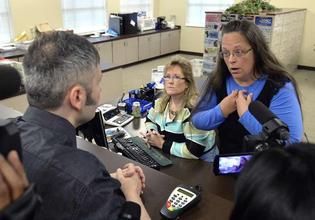 FILE - Rowan County Clerk Kim Davis, right, talks with David Moore following her office's refusal to issue marriage licenses at the Rowan County Courthouse in Morehead, Ky., on Sept. 1 2015. (AP Photo/Timothy D. Easley, File)