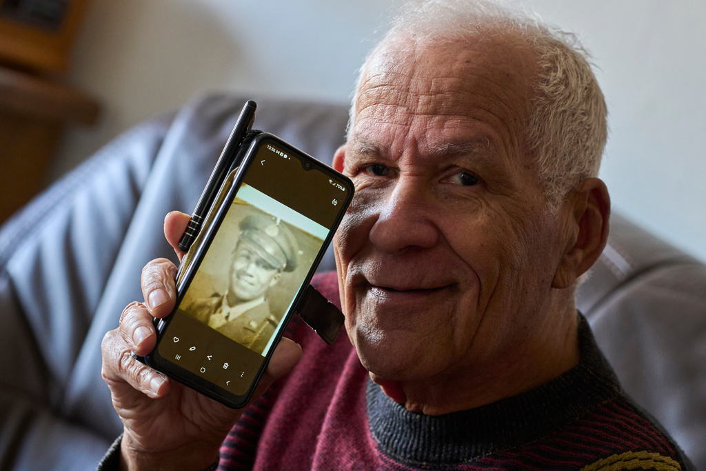 Seventy-nine-year-old Cor Linssen, son of a Black WWII soldier and a White mother, shows a picture of his father on his mobile phone during an interview in Roermond, Netherlands, Thursday, Dec. 11, 2025. (AP Photo/Peter Dejong)