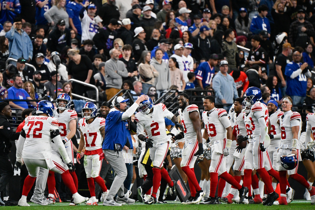 New York Giants cornerback Deonte Banks (2) is congratulated by interim head coach Mike Kafka after scoring a touchdown during the second half of an NFL football game against the Las Vegas Raiders Sunday, Dec. 28, 2025, in Las Vegas. (AP Photo/David Becker)