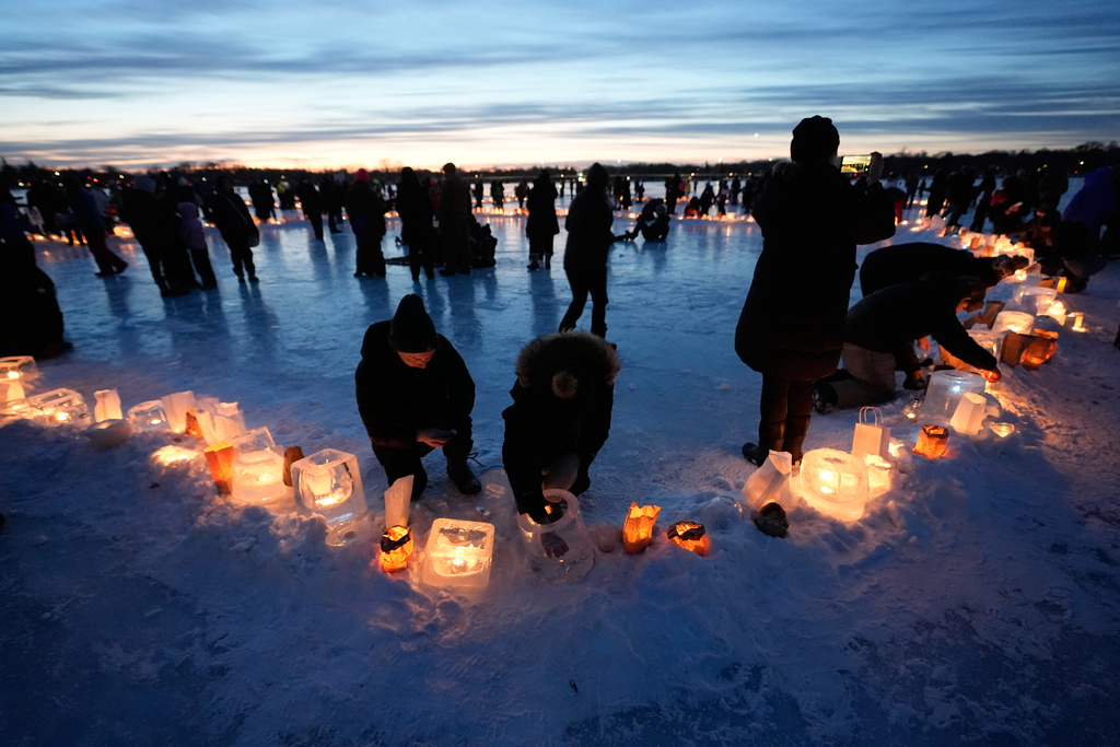Activists gather in protest to light candles on frozen Lake Nokomis, spelling, "Ice Out" on Saturday, Jan. 31, 2026, in Minneapolis. (AP Photo/Alex Brandon)