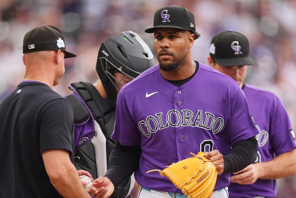 Colorado Rockies manager Warren Schaeffer, left, takes the ball from relief pitcher Jaden Hill, front right, who is pulled from the mound after giving up a two-run single to Milwaukee Brewers' Brice Turang in the sixth inning of a baseball game Sunday, June 7, 2026, in Denver. (AP Photo/David Zalubowski)