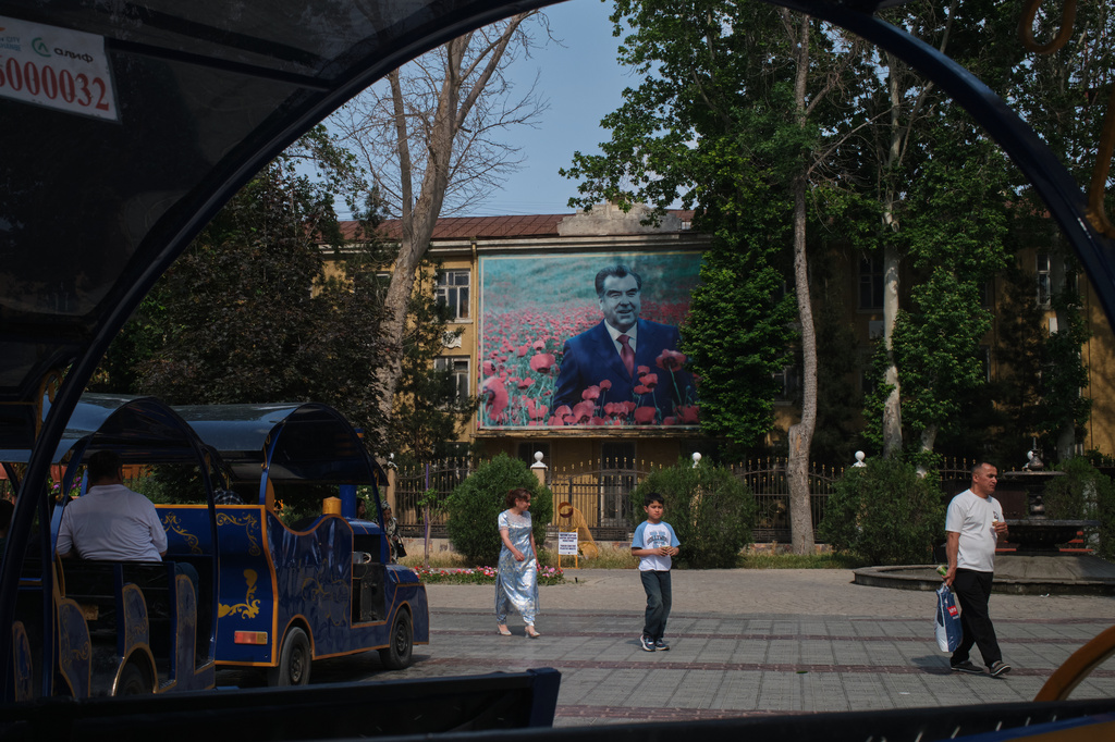 People walk past a portrait of Tajik President Emomali Rahmon in Khujand, Tajikistan, Sunday, May 3, 2026. (AP Photo/Jon Orbach)