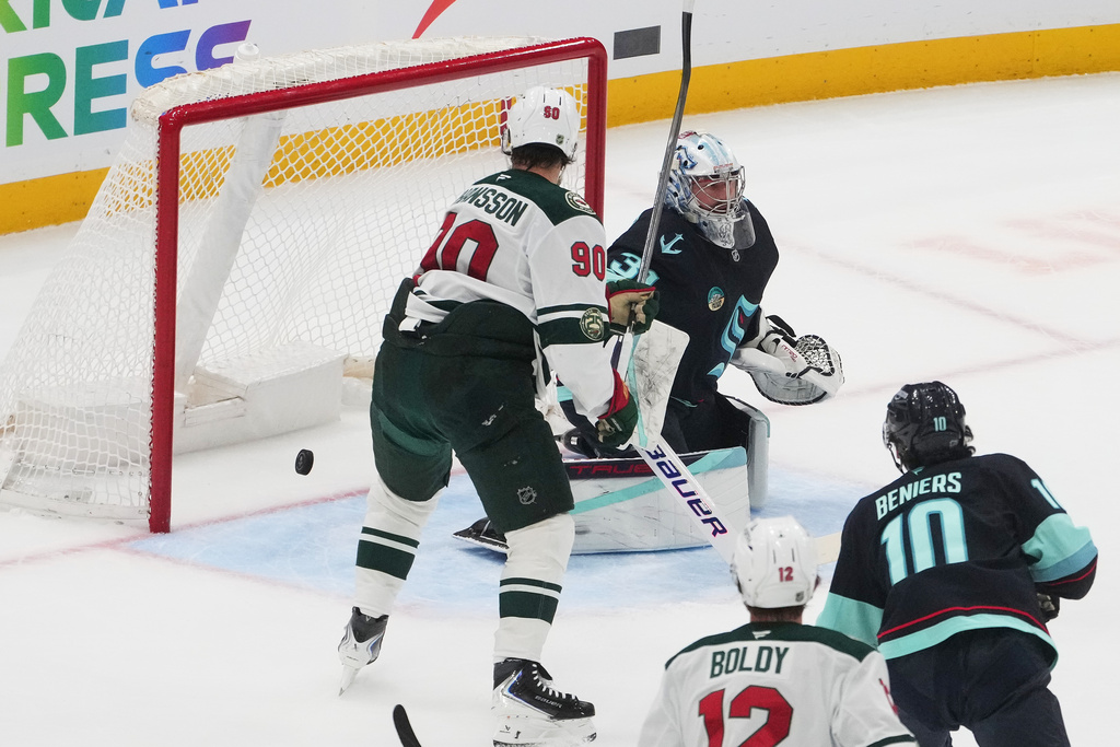 Minnesota Wild left wing Marcus Johansson (90) watches a goal from defenseman Brock Faber go in the net past Seattle Kraken goaltender Philipp Grubauer (31) during the first period of an NHL hockey game Thursday, Jan. 8, 2026, in Seattle. (AP Photo/Lindsey Wasson)