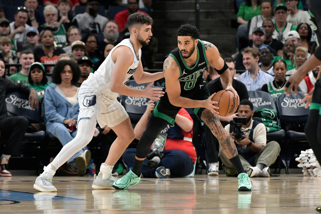 Boston Celtics forward Jayson Tatum (0) handles the ball against Memphis Grizzlies guard Ty Jerome, left, in the first half of an NBA basketball game Friday, March 20, 2026, in Memphis, Tenn. (AP Photo/Brandon Dill)