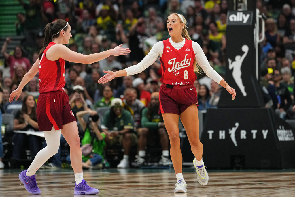 Indiana Fever guard Caitlin Clark, left, greets guard Sophie Cunningham (8) after Cunningham made a basket against the Seattle Storm during the first half of a WNBA basketball game, Tuesday, July 28, 2026, in Seattle. (AP Photo/Lindsey Wasson)