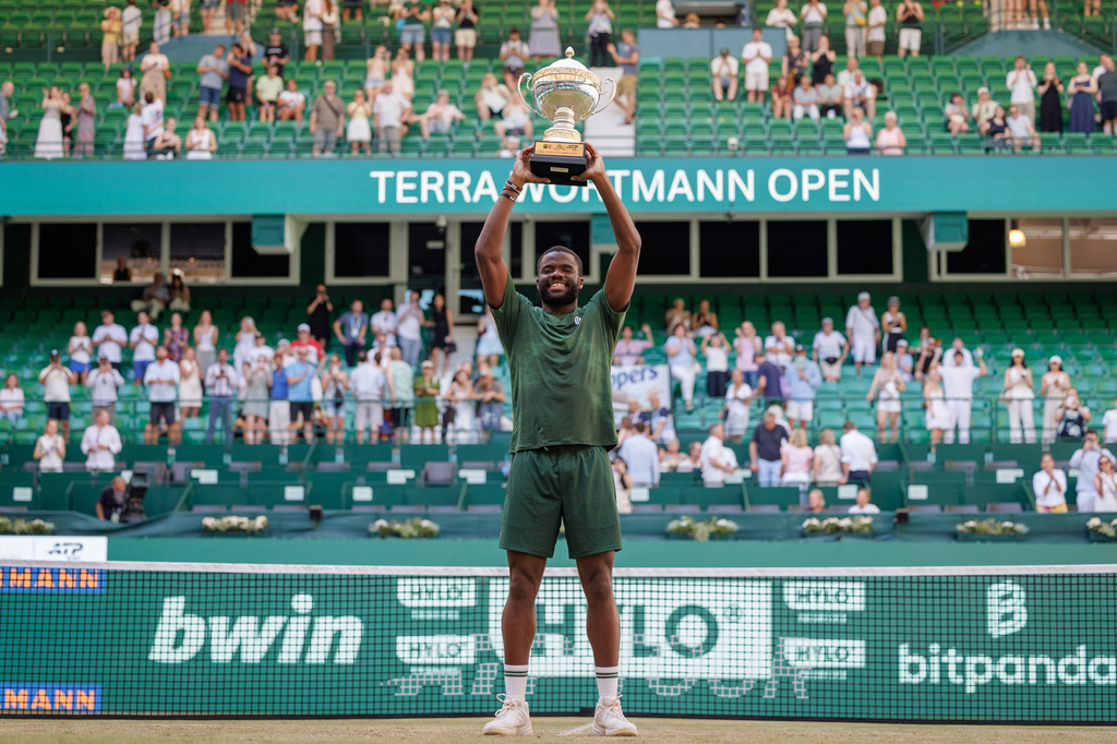 El estadounidense Frances Tiafoe celebra con el trofeo tras vencer a su compatriota Taylor Fritz en la final del torneo de Halle el domingo 21 de junio del 2026. (Friso Gentsch/dpa via AP)