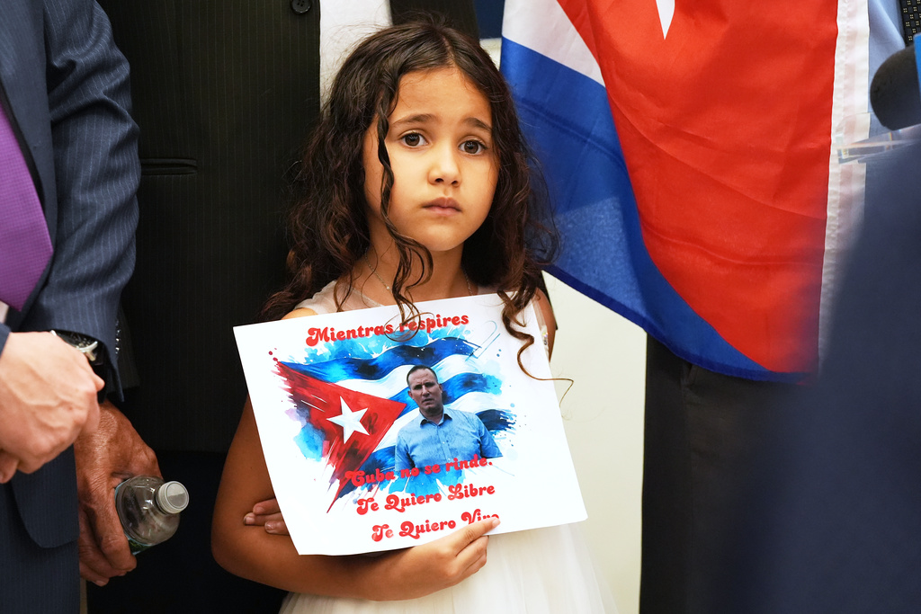 Vanessa Ferrer, the niece of Cuban dissident Jose Daniel Ferrer, holds a sign during his news conference in Miami, Florida, Monday, Oct. 13, 2025, the day he left Cuba for exile in the U.S. The sign reads in Spanish: "As long as you breath, Cuba does not give up. I want you free. I want you alive." (AP Photo/Marta Lavandier)