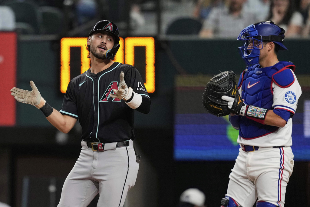 Arizona Diamondbacks' Blaze Alexander celebrates his solo home run as Texas Rangers' Kyle Higashioka looks on in the third inning of a baseball game Tuesday, Aug. 12, 2025, in Arlington, Texas. (AP Photo/Tony Gutierrez)