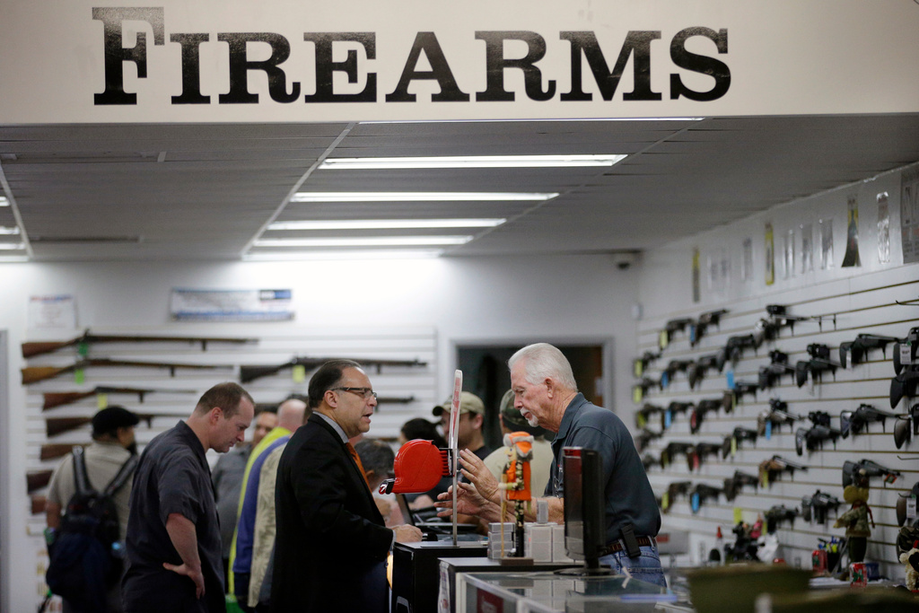 FILE - Sales associate Mike Conway, right, shows Paul Angulo guns at Bullseye Sport gun shop in Riverside, Calif on Wednesday, Dec. 9, 2015, (AP Photo/Jae C. Hong, File)