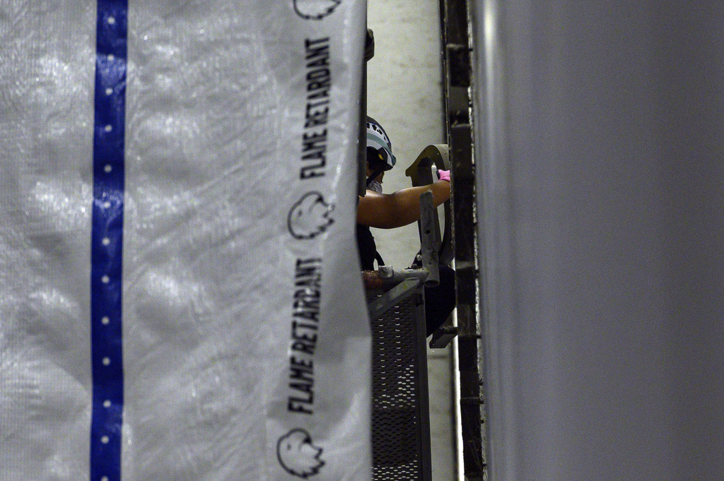 A worker removes a letter from President Donald Trump's name from the wall of the John F. Kennedy Center for the Performing Arts in Washington, Saturday, June 13, 2026. (AP Photo/Cliff Owen)