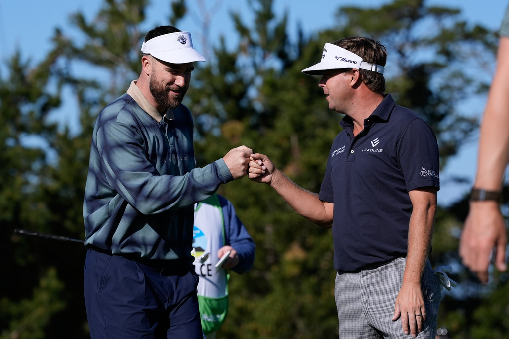 Kansas City Chiefs' Travis Kelce, left, fist bumps Keith Mitchell after making a putt on the 10th green at Spyglass Hill Golf Course during the first round of the AT&T Pebble Beach Pro-Am golf tournament in Pebble Beach, Calif., Thursday, Feb. 12, 2026. (AP Photo/Godofredo A. Vásquez)