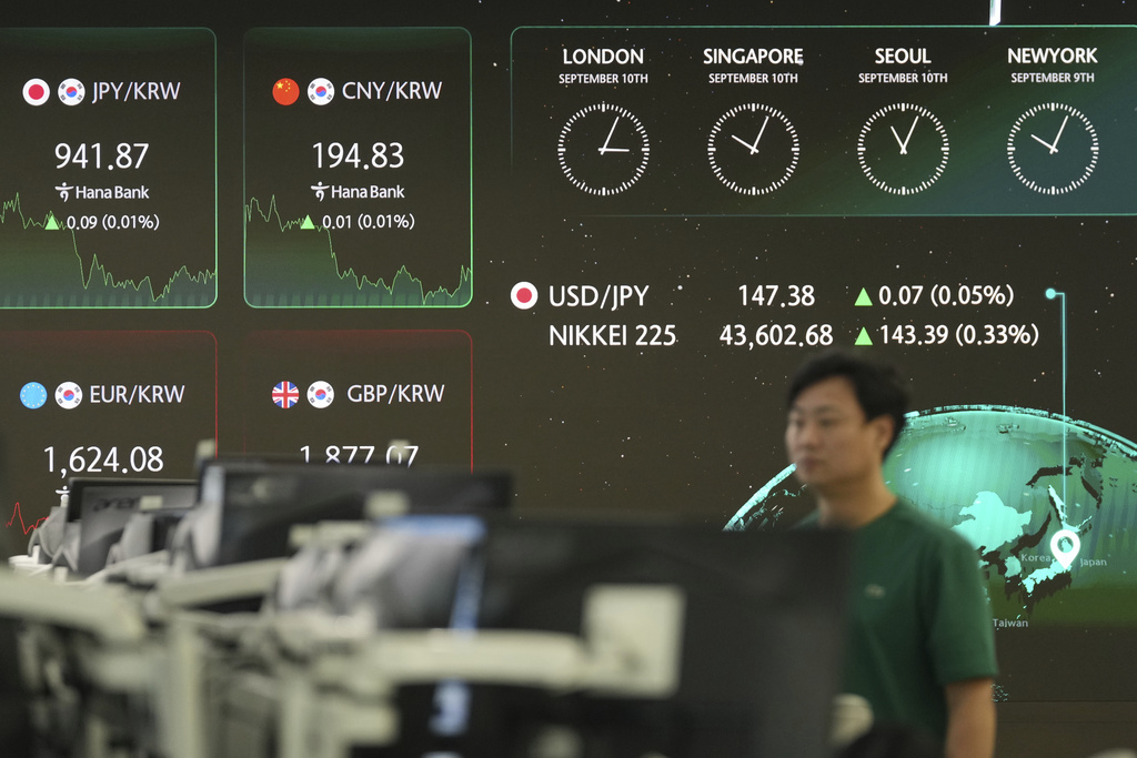 A dealer walks near the screens showing the foreign exchange rates at a dealing room of Hana Bank in Seoul, South Korea, Wednesday, Sept. 10, 2025. (AP Photo/Lee Jin-man)