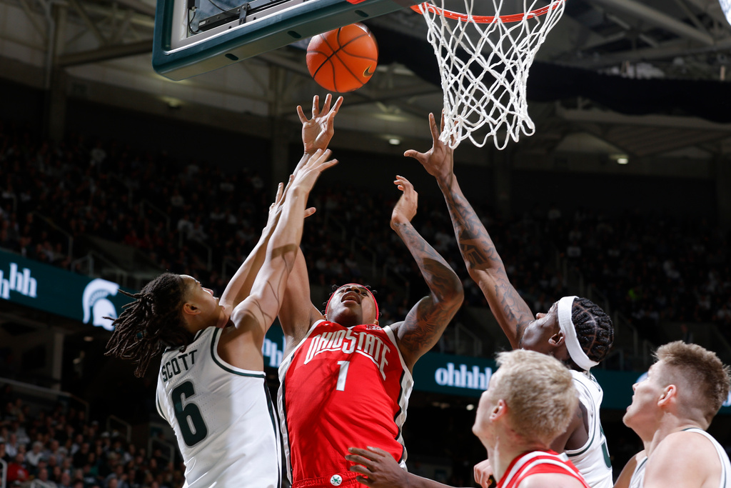 Ohio State forward Amare Bynum (1), Michigan State forward Jordan Scott (6) and Michigan State forward Coen Carr, top right, reach for a rebound during the first half of an NCAA college basketball game, Sunday, Feb. 22, 2026, in East Lansing, Mich. (AP Photo/Al Goldis)